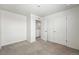 Bright bedroom featuring neutral carpet, white walls, and convenient closet access at 226 Racer St, Bennett, CO 80102