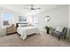 Light filled bedroom featuring neutral carpet, large windows, and a comfortable bed with tasteful decor at 226 Racer St, Bennett, CO 80102