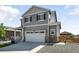 Beautiful two-story home boasts a two-car garage, neutral exterior paint, and professionally landscaped yard at 226 Racer St, Bennett, CO 80102