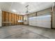 Spacious garage featuring concrete floor, drywall, and overhead door with opener at 226 Racer St, Bennett, CO 80102