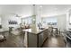 Bright open-concept kitchen featuring a granite countertop island, modern appliances, and seamless flow into the living area at 226 Racer St, Bennett, CO 80102
