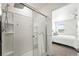 Modern shower featuring tiled walls, glass door, and chrome fixtures in the bright and updated bathroom at 226 Racer St, Bennett, CO 80102
