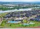 Aerial view featuring homes, a pool, and tennis courts near a lake at 12826 Lake Port St, Longmont, CO 80504
