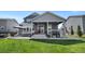 Backyard featuring a covered patio, hot tub, grill, and green lawn for outdoor enjoyment at 12826 Lake Port St, Longmont, CO 80504