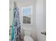 Bathroom featuring a toilet, walk-in shower with decorative curtain and a window letting in natural light at 12826 Lake Port St, Longmont, CO 80504