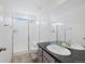Bright bathroom with a sleek black vanity, a large mirror, and a shower with glass doors at 12826 Lake Port St, Longmont, CO 80504