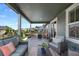 Comfortable covered patio with stylish seating, a ceiling, and views of the landscaped backyard at 12826 Lake Port St, Longmont, CO 80504