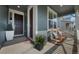 Inviting covered porch featuring rocking chairs with stylish pillows, plants, and a welcoming front door at 12826 Lake Port St, Longmont, CO 80504