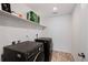 Laundry room featuring a dark washer and dryer, shelving, and tile floor at 12826 Lake Port St, Longmont, CO 80504