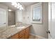 Bright bathroom with stone countertops, wood cabinets, large mirror and plantation shutters at 4505 W 100Th Ave, Westminster, CO 80031