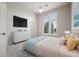 Bright bedroom features a ceiling fan, large windows, a dresser with a television, and a queen sized bed at 4505 W 100Th Ave, Westminster, CO 80031