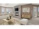 Comfortable living room with stone fireplace, television, hardwood floors, light gray sofa, and multiple windows at 4505 W 100Th Ave, Westminster, CO 80031