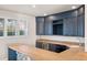 Wet bar features granite countertops, stainless steel appliances, stone surround, and navy cabinets at 4505 W 100Th Ave, Westminster, CO 80031