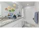 Bright bathroom featuring double sinks with granite counters and white cabinets with a shower at 25064 E Archer Pl, Aurora, CO 80018
