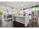 A bright, modern kitchen boasts a large island, stainless steel appliances, and a dining area at 25064 E Archer Pl, Aurora, CO 80018
