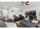 A cozy living room features a leather sofa, a ceiling fan, and a white staircase at 25064 E Archer Pl, Aurora, CO 80018
