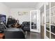Well lit office space with black leather sofa and french door at 25064 E Archer Pl, Aurora, CO 80018