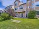Spacious backyard with well-maintained grass, a patio, and a charming two-story home in the background at 6827 S Webster St # E, Littleton, CO 80128