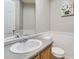Cozy bathroom features a neutral color palette and a classic vanity with a framed mirror at 6827 S Webster St # E, Littleton, CO 80128