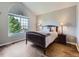 Charming bedroom with large window, vaulted ceiling, and warm laminate wood flooring at 6827 S Webster St # E, Littleton, CO 80128