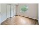 Bright bedroom features wood floors, a window with a view, and a double door closet at 6827 S Webster St # E, Littleton, CO 80128