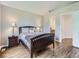 Inviting bedroom featuring laminate floors, a neutral color palette, and access to a private bath at 6827 S Webster St # E, Littleton, CO 80128