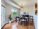 Bright dining room featuring hardwood floors, a large window, and stylish lighting fixtures at 6827 S Webster St # E, Littleton, CO 80128