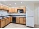 Well-lit kitchen featuring wood cabinets, laminate countertops, and a white refrigerator at 6827 S Webster St # E, Littleton, CO 80128