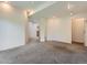 Neutral living room with bright lighting, plush carpeting, and access to other rooms at 6827 S Webster St # E, Littleton, CO 80128