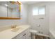 Updated bathroom features vinyl flooring, vanity and mirror, toilet, and window at 6698 S Wellington Ct, Centennial, CO 80121
