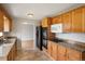 Functional kitchen featuring wood cabinets, granite countertops, tile floors, and modern appliances for easy meal prep at 6698 S Wellington Ct, Centennial, CO 80121