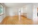 Spacious living room featuring gleaming hardwood floors, neutral walls, and a seamless flow to adjacent spaces at 6698 S Wellington Ct, Centennial, CO 80121