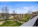 Scenic backyard view from the deck showcases a lush lawn and landscaping with trees in the distance at 6994 S Fultondale Cir, Aurora, CO 80016