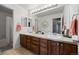 Bright bathroom with double sink vanity, decorative mirror, and ample storage at 6994 S Fultondale Cir, Aurora, CO 80016