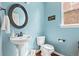 Stylish half bathroom with blue walls, a pedestal sink, and modern fixtures at 6994 S Fultondale Cir, Aurora, CO 80016