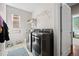 Functional laundry room with modern washer and dryer, storage shelves, and natural light at 6994 S Fultondale Cir, Aurora, CO 80016