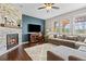 Cozy living room with a stone fireplace, large windows, and a comfortable gray sectional sofa at 6994 S Fultondale Cir, Aurora, CO 80016