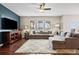 Bright living room with hardwood floors, a comfortable sofa, and large windows offering natural light at 6994 S Fultondale Cir, Aurora, CO 80016