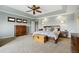 Large primary bedroom featuring a tray ceiling, neutral carpet, and plenty of space at 6994 S Fultondale Cir, Aurora, CO 80016