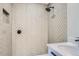Close-up of the shower with stylish herringbone tile, a rainfall showerhead, and a convenient in-wall niche at 3975 Yates St, Denver, CO 80212