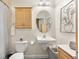 Cozy bathroom with a pedestal sink, toilet, and vanity cabinet for storage at 1950 N Logan St # 905, Denver, CO 80203