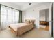A bright bedroom with a wooden bed frame and large windows, adjacent living area at 1950 N Logan St # 905, Denver, CO 80203