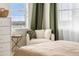 Bedroom with a cozy chair near a bright window with city views and modern décor at 1950 N Logan St # 905, Denver, CO 80203