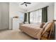 Bright bedroom features natural light, white walls, neutral carpet, and a stylish ceiling fan at 1950 N Logan St # 905, Denver, CO 80203