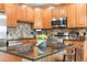 Kitchen with granite countertop island, wood cabinets and stainless steel appliances at 1950 N Logan St # 905, Denver, CO 80203