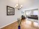 Dining room with hardwood floors, a chandelier, and grey sofa set in the adjacent living room at 13853 W 66Th Pl, Arvada, CO 80004