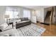 Bright living room boasts hardwood floors, a neutral palette, and entry to staircase at 13853 W 66Th Pl, Arvada, CO 80004