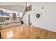 Open-concept living area featuring hardwood floors, stairs leading to a second story and kitchen access at 13853 W 66Th Pl, Arvada, CO 80004