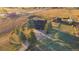 Aerial view of modern house featuring lush landscaping, a circular driveway and outbuildings at 2312 Arabian Trl, Elizabeth, CO 80107