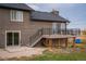 Backyard view of the house featuring a spacious deck with metal railings and a dark roof at 2312 Arabian Trl, Elizabeth, CO 80107